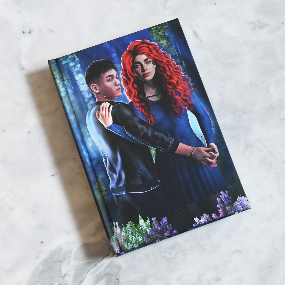 Notebook with a cover featuring two people embracing in a forest setting.
