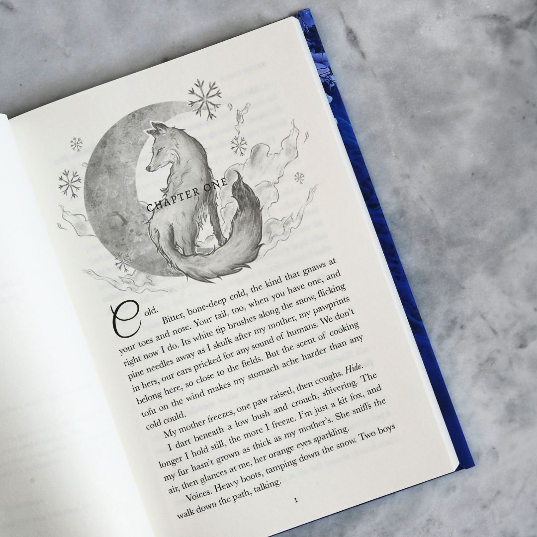 Open book with a chapter title page featuring a wolf illustration on a textured surface.