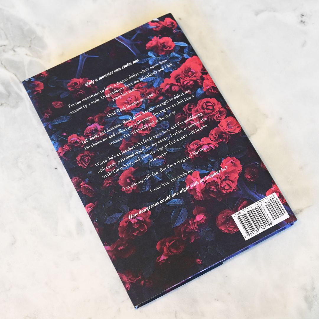 Book with red floral design and text on a white surface